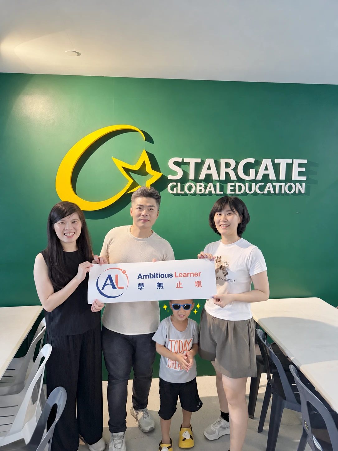 STARGATE 세부 어학원의 초록색 로고 월 앞에서 2026년 9월에 학교를 방문한 Ambitious Learner 팀